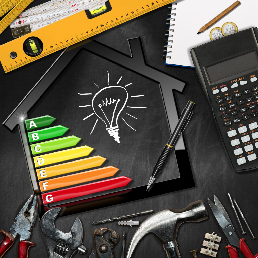 Illustrative image of sustainable home improvements, featuring a house outline with a light bulb drawing, energy efficiency rating from A to G, and various tools such as a wrench, hammer, and calculator, all laid out on a black background indicating planning for eco-friendly renovations.